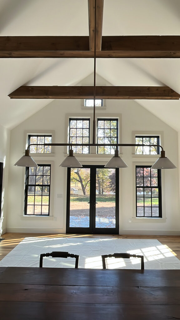 Interior painting project in Darien CT with vaulted white walls and bold black window contrast